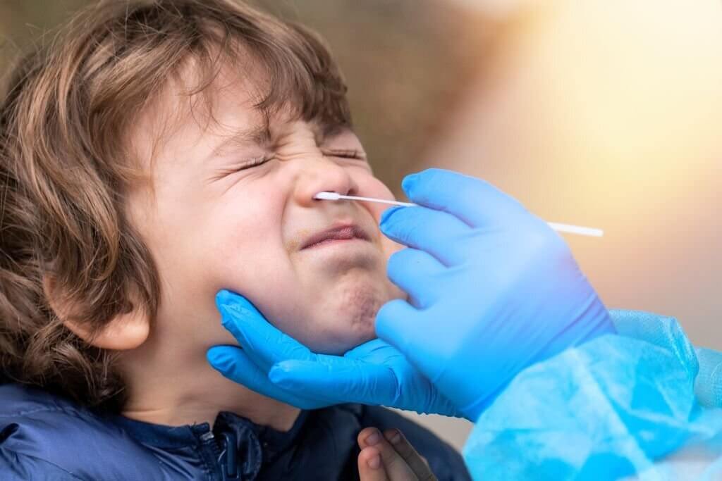 Female nurse performing a Covid-19 test on a boy